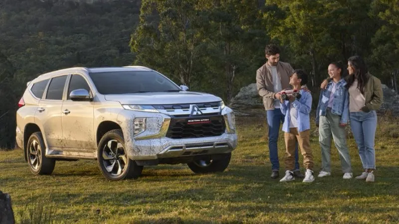 Cliente recibiendo su vehículo Mitsubishi después de una revisión en el taller autorizado.