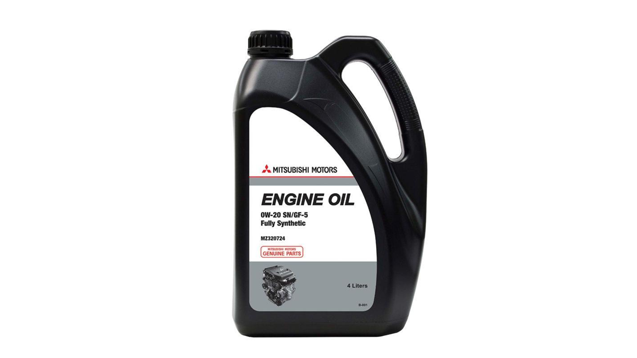 Aceites de motor originales Mitsubishi junto a un técnico consultando las especificaciones del vehículo
