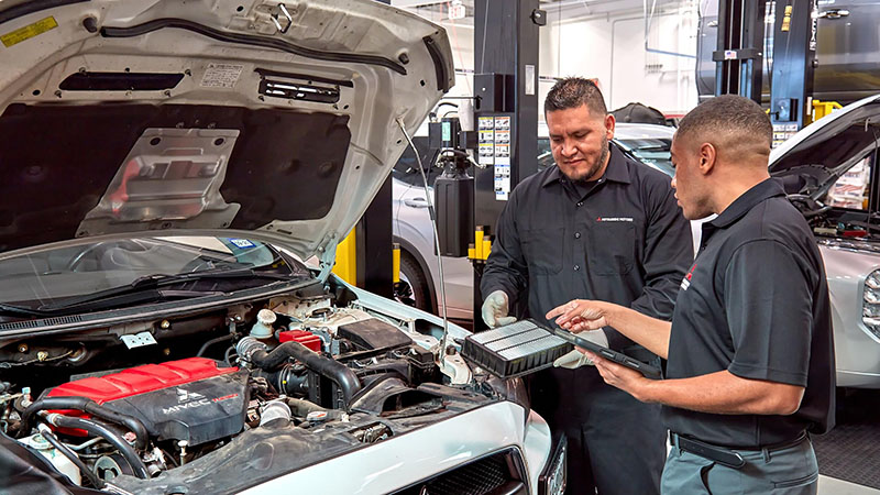Técnico de Mitsubishi realizando un cambio de aceite en un vehículo dentro del taller autorizado